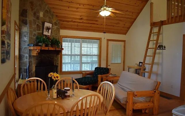 A living room with a table and chairs and a fireplace