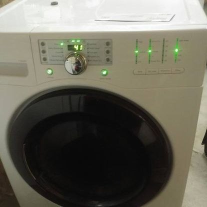 A white washer and dryer with green lights on the front