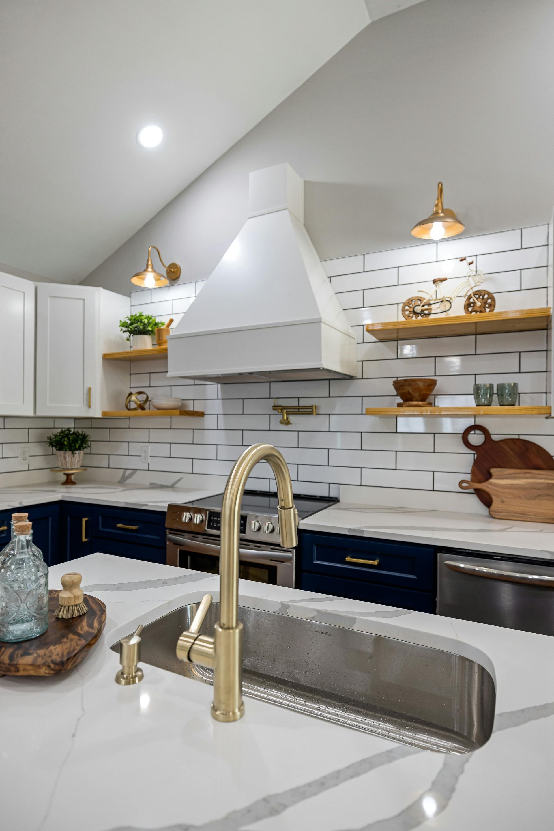 A kitchen with a sink , stove , and hood.