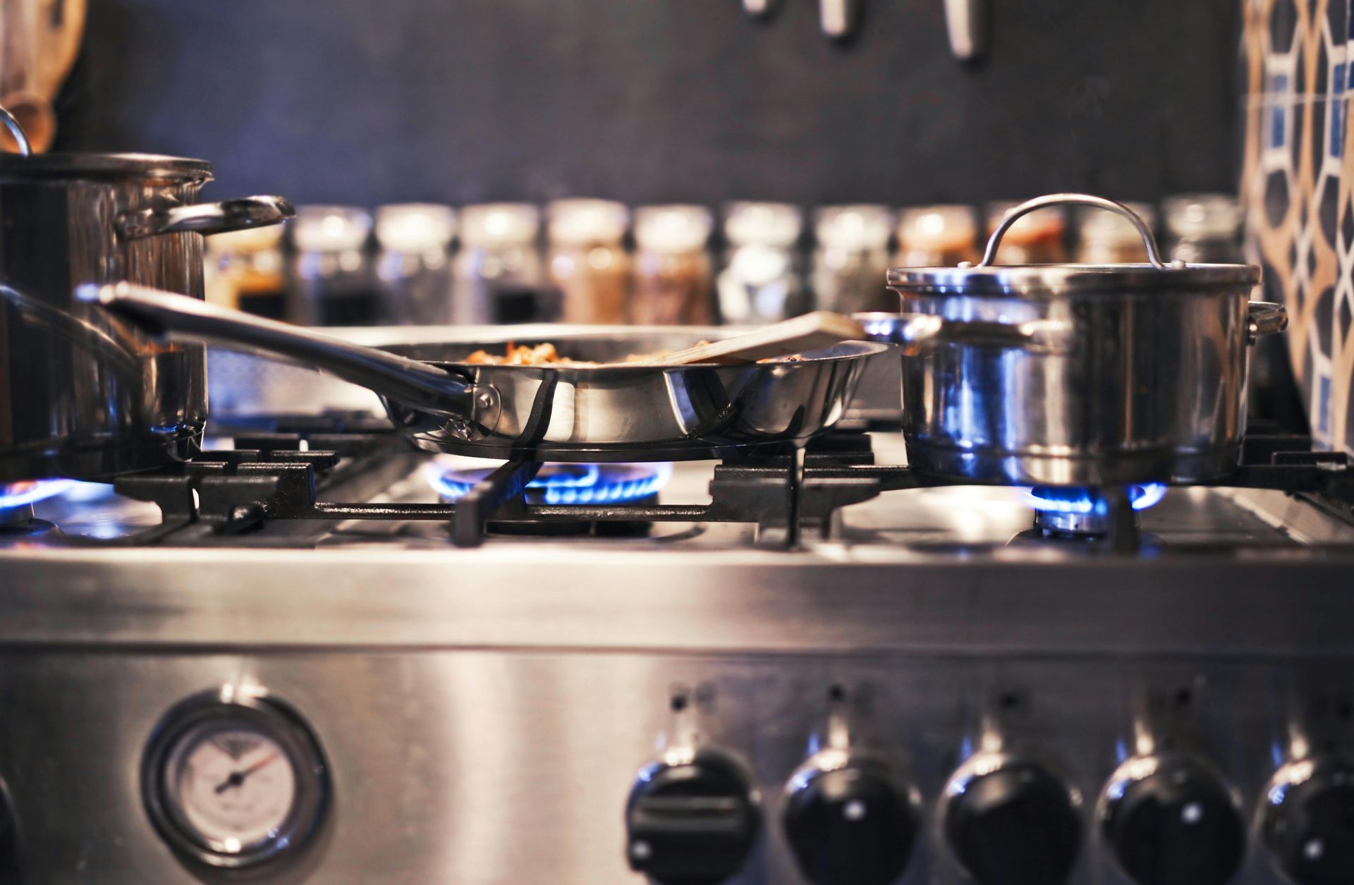 A stove with pots and pans cooking on it in a kitchen.