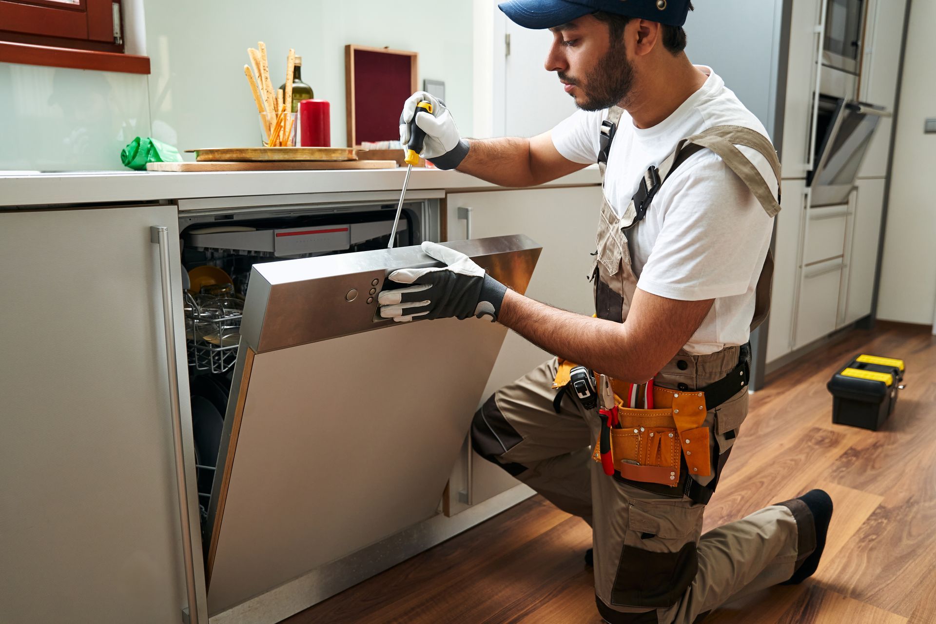 Technician fixing a washing machine to avoid major issues.