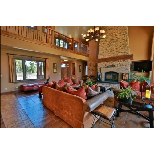 Kitchen with white cabinets, wooden walls, and hardwood floors. A wine cooler is visible.