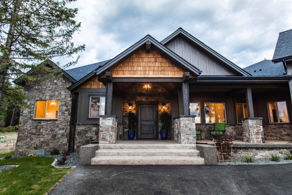 Stone and gray siding house with a covered porch and steps.