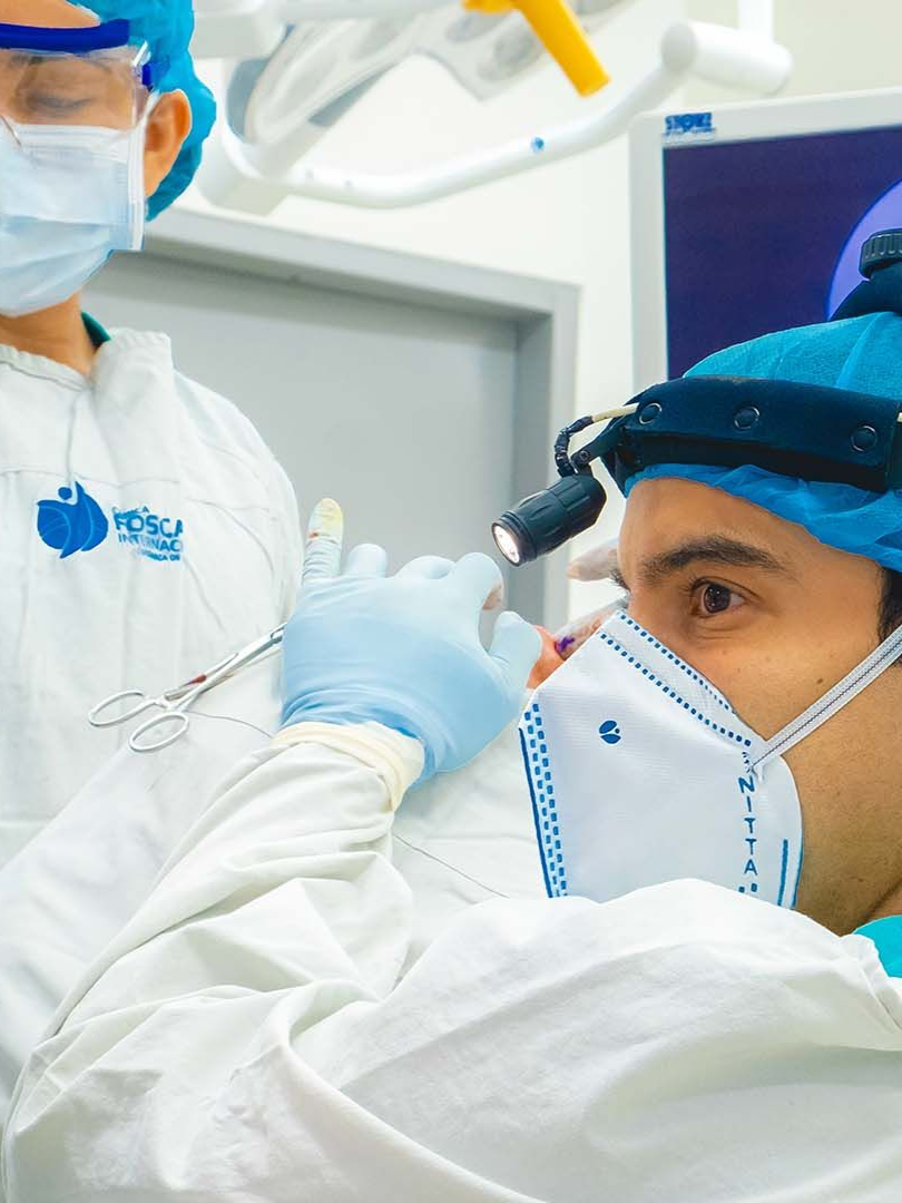 Cirujano examinando la nariz de un paciente después de una cirugía, con equipo de protección. Primer plano, entorno médico.
