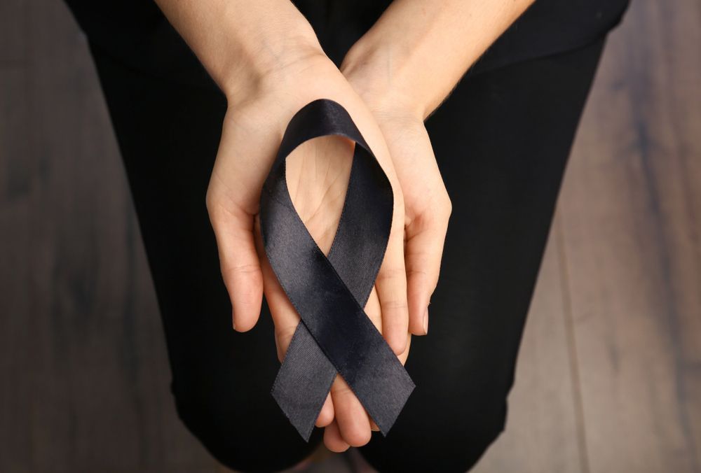 A Person Is Holding a Black Ribbon in Their Hands  - A Better Way Funerals in St Leonards, NSW