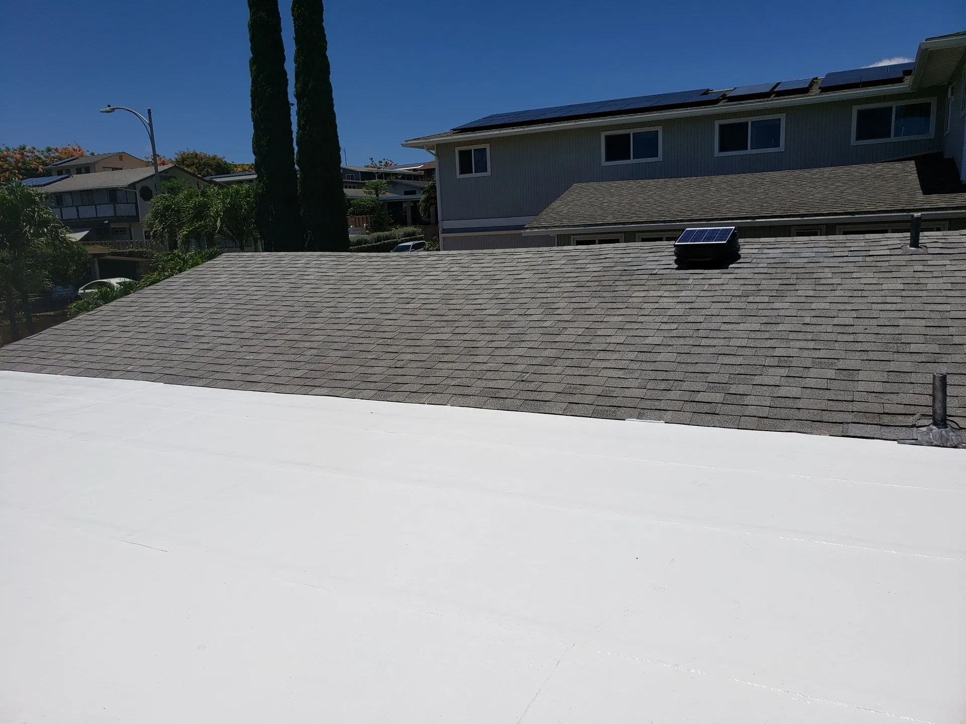 A house with a white roof and solar panels on the roof.