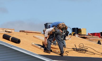 A group of men are working on a roof.