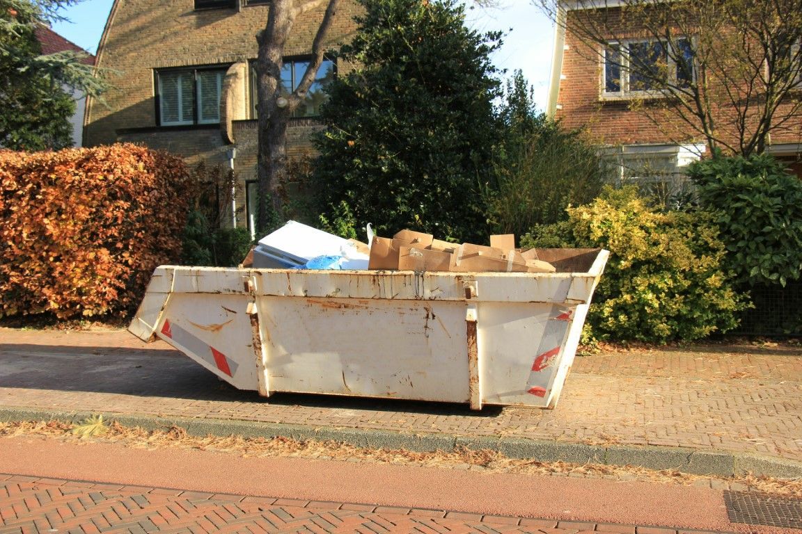 Roll-off dumpster filled with construction debris and household junk in Goldsboro, NC.