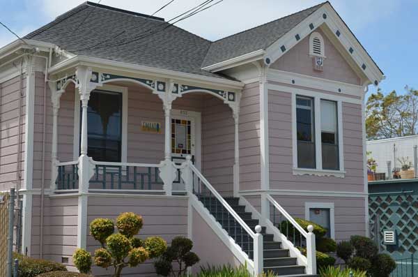 Pink Victorian house with white trim, porch, and steps.