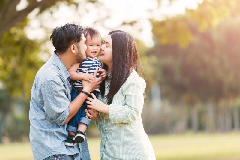 couple kissing their baby