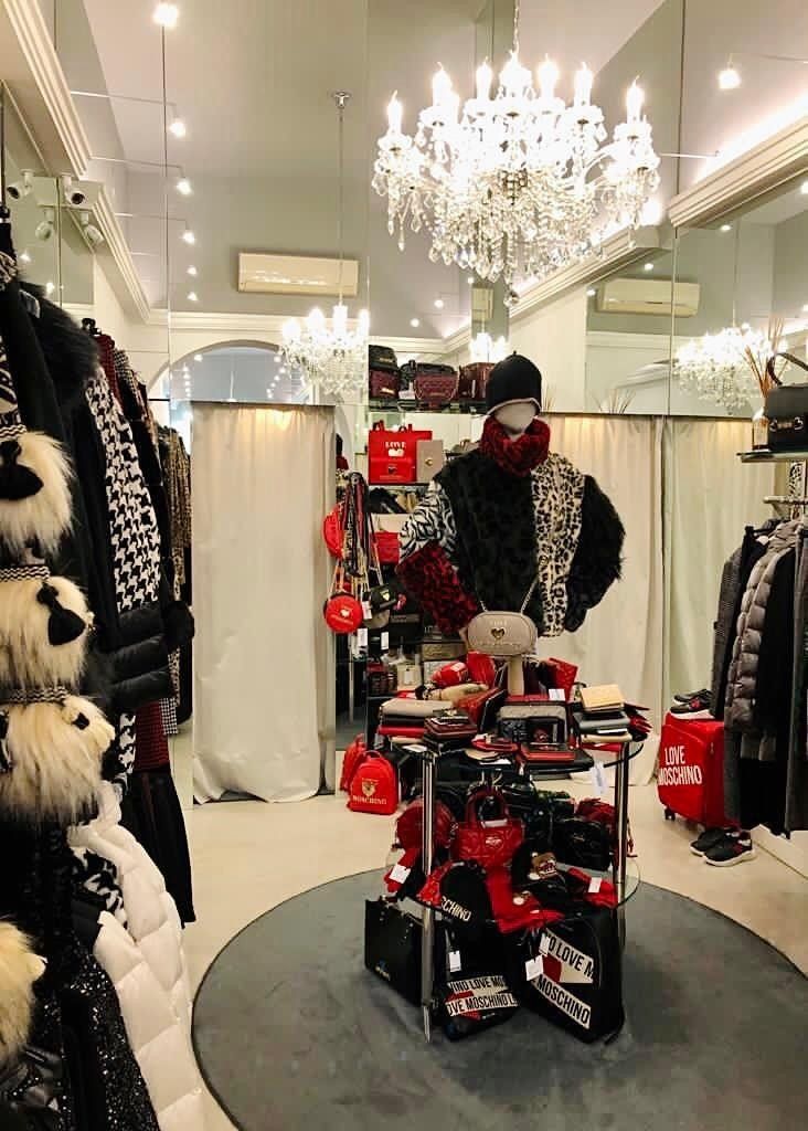 degli appendini con le borse, altri accessori appesi e un salvagente con scritto Moschino