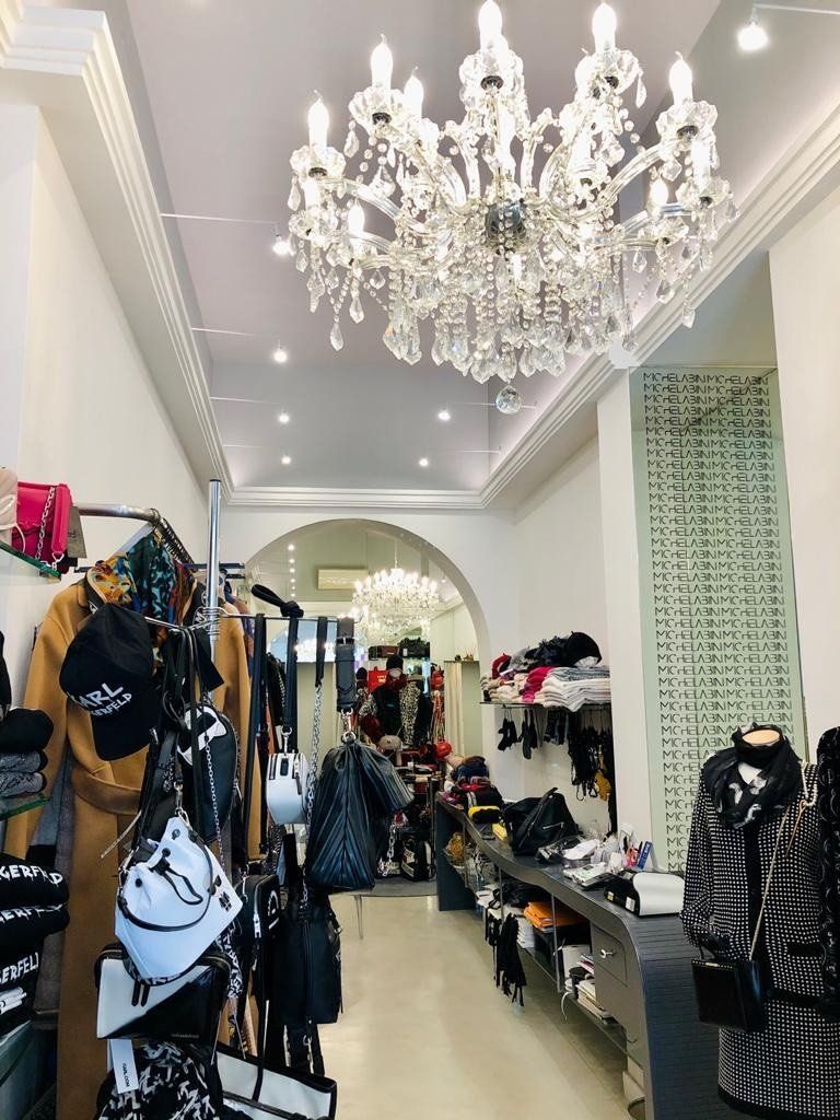 due manichini con abiti di color bianco e due salvagenti con scritto Buone Vacanze Moschino