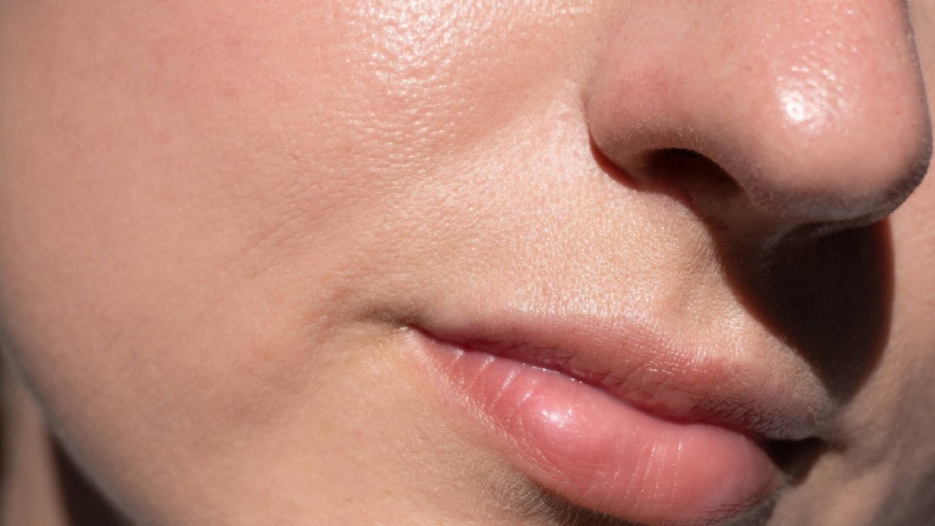 Close-up of a person's face showing skin texture, nose, and slightly parted lips.