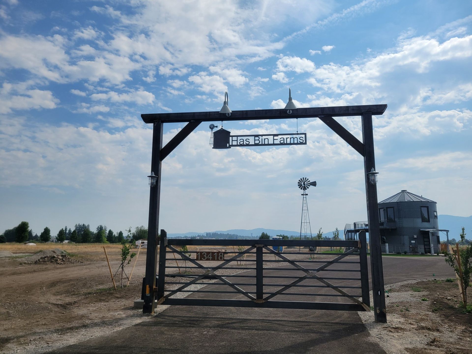 Wooden gate leading to a ranch with a sign reading 