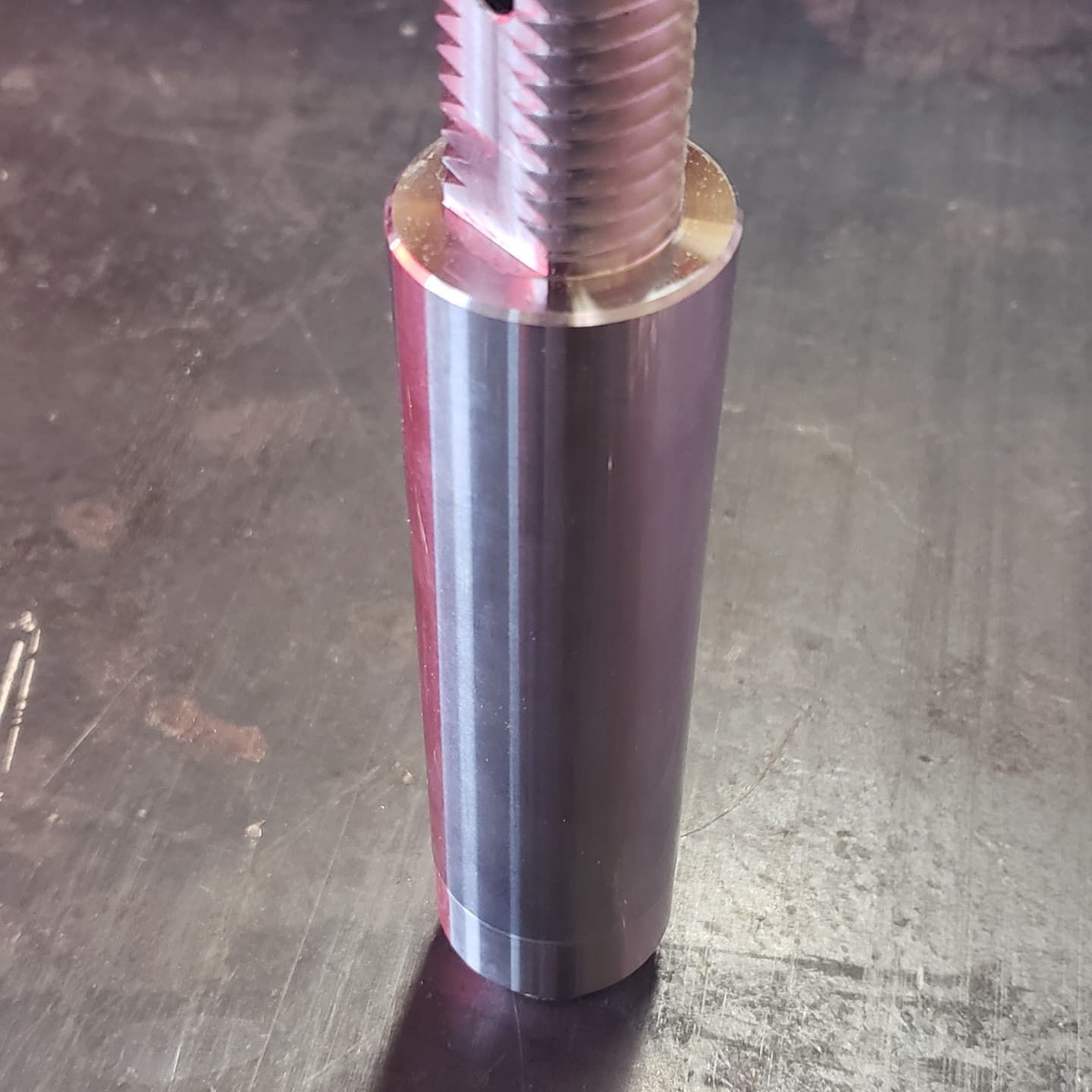 Silver cylindrical metal component with threaded top.