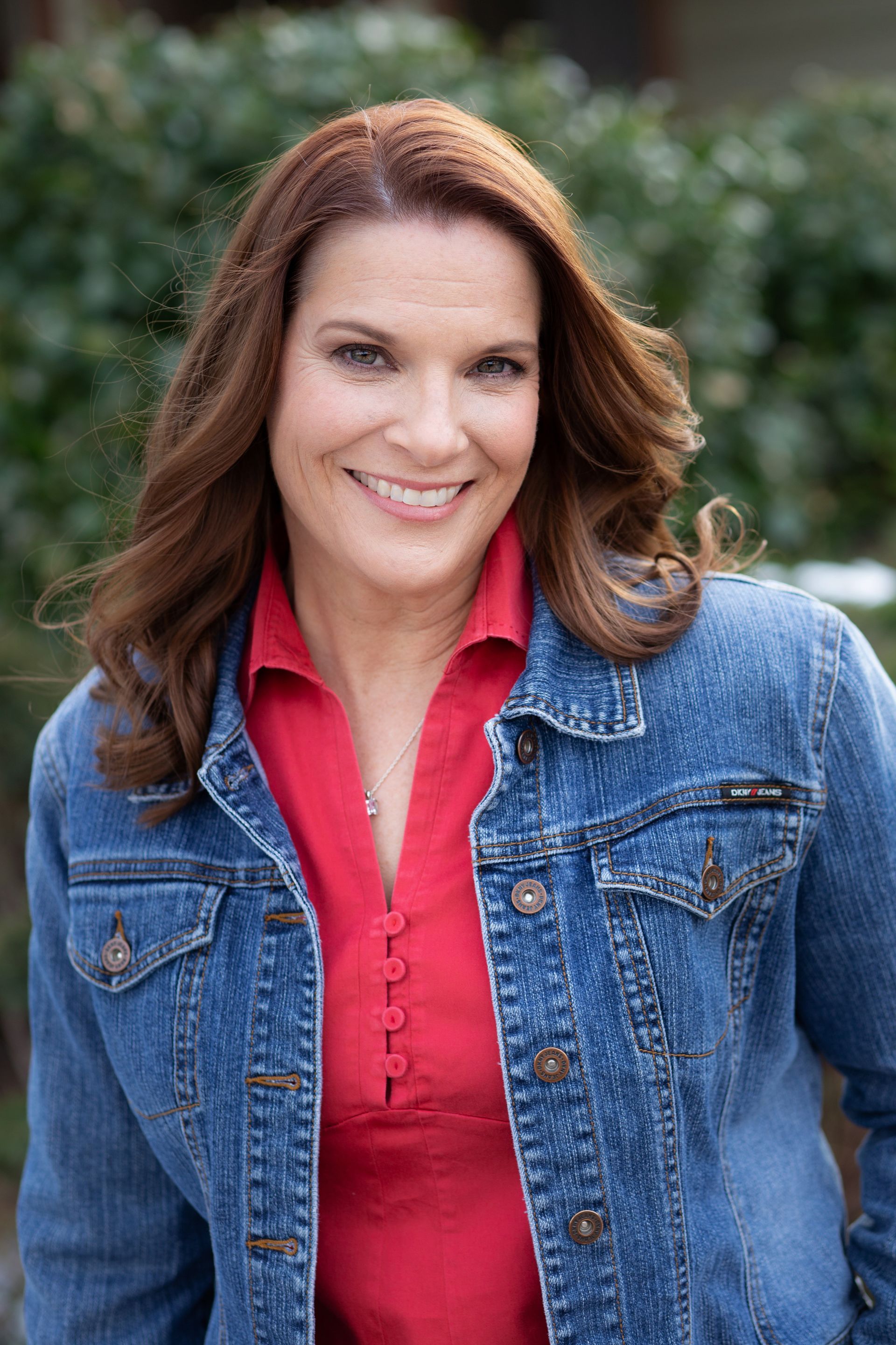 A man is holding a dog in his arms and the dog is wearing a sweater.