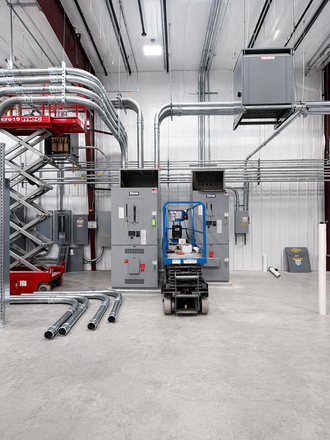 A frontal view of industrial electrical conduit, wiring, and switches