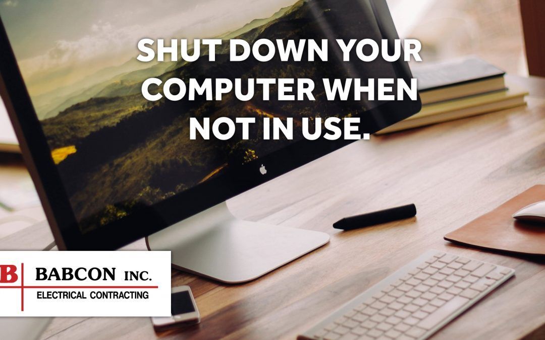 A computer monitor is sitting on a wooden desk next to a keyboard and mouse.