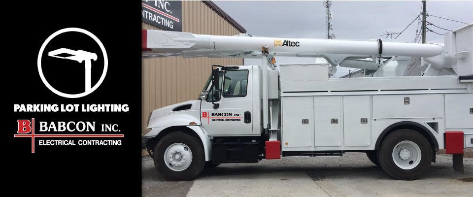 A white utility truck is parked in front of a building.