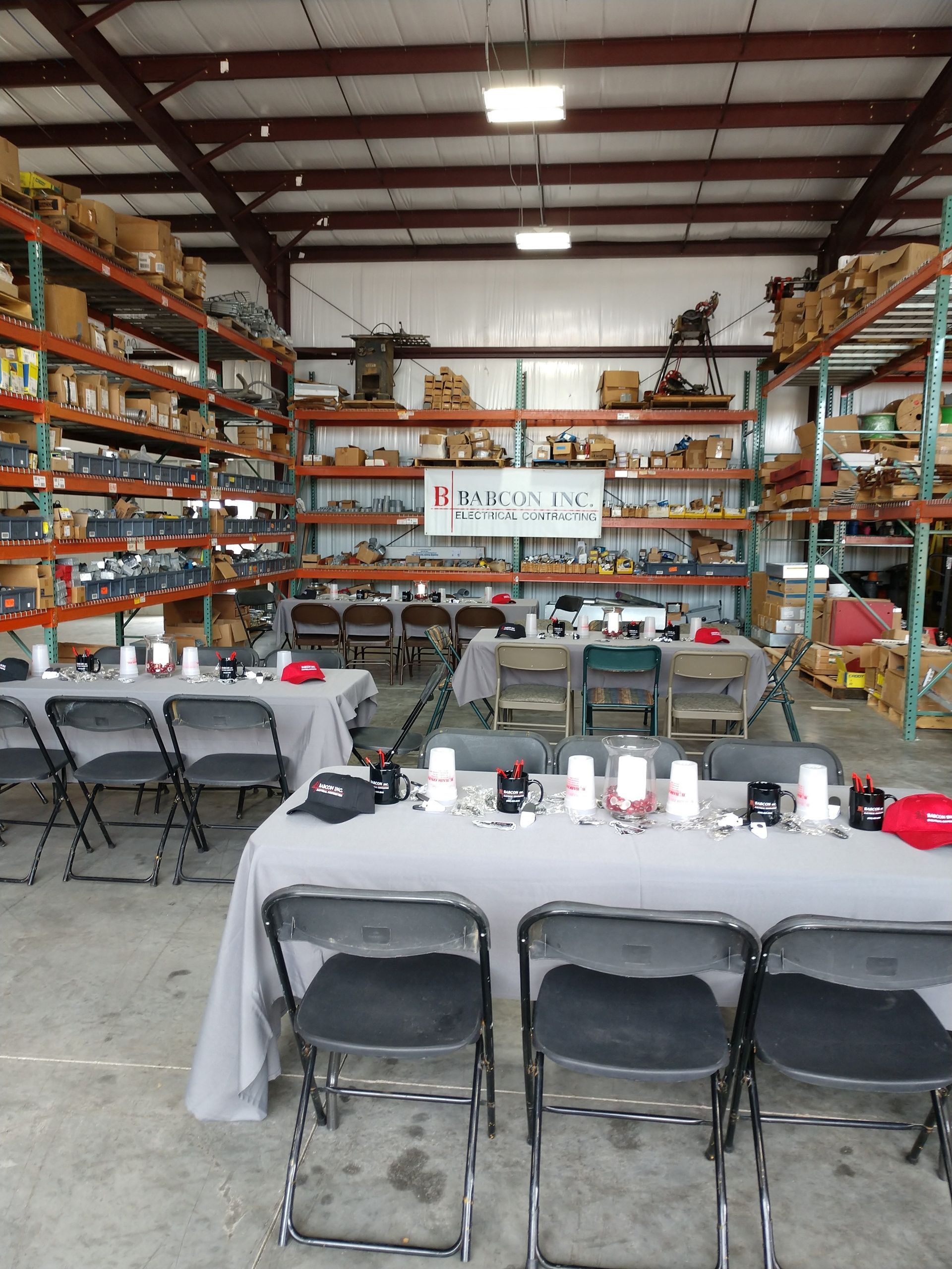 A warehouse with tables and chairs set up for a meeting