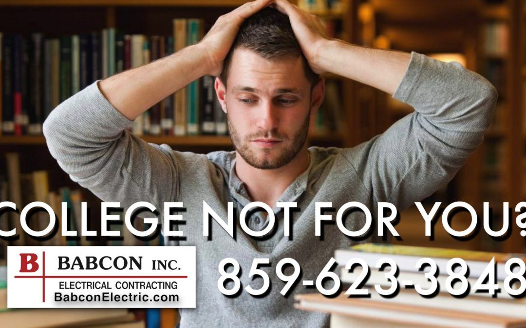 A man is sitting in a library with his hands on his head.