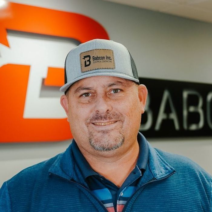 A man wearing a baseball cap with the letter b on it