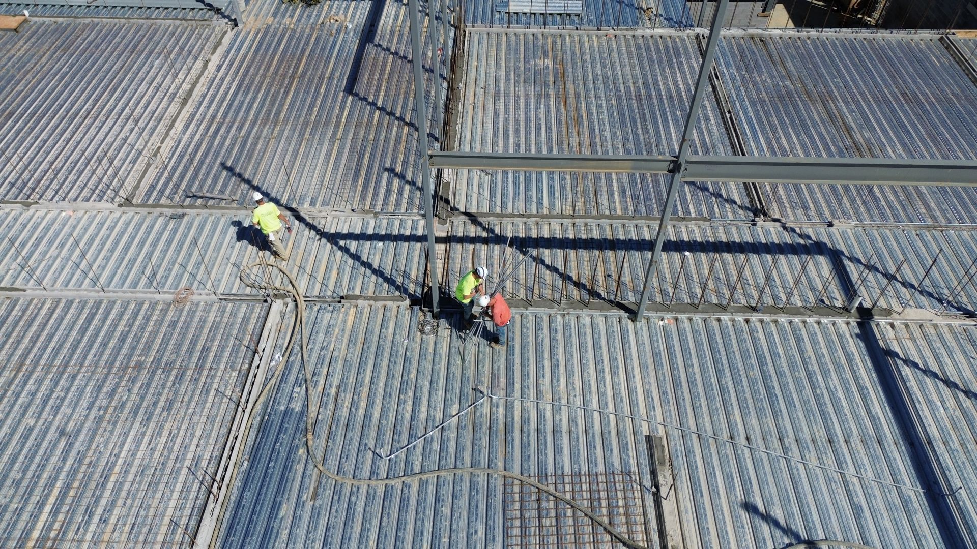 A group of construction workers are standing on top of a concrete floor.