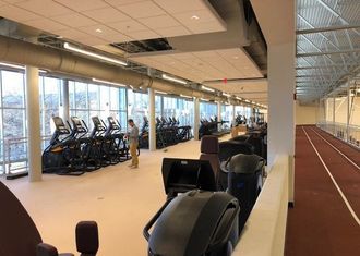 A gym with a running track and a lot of exercise equipment