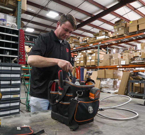 A man wearing headphones is working on a server in a data center.