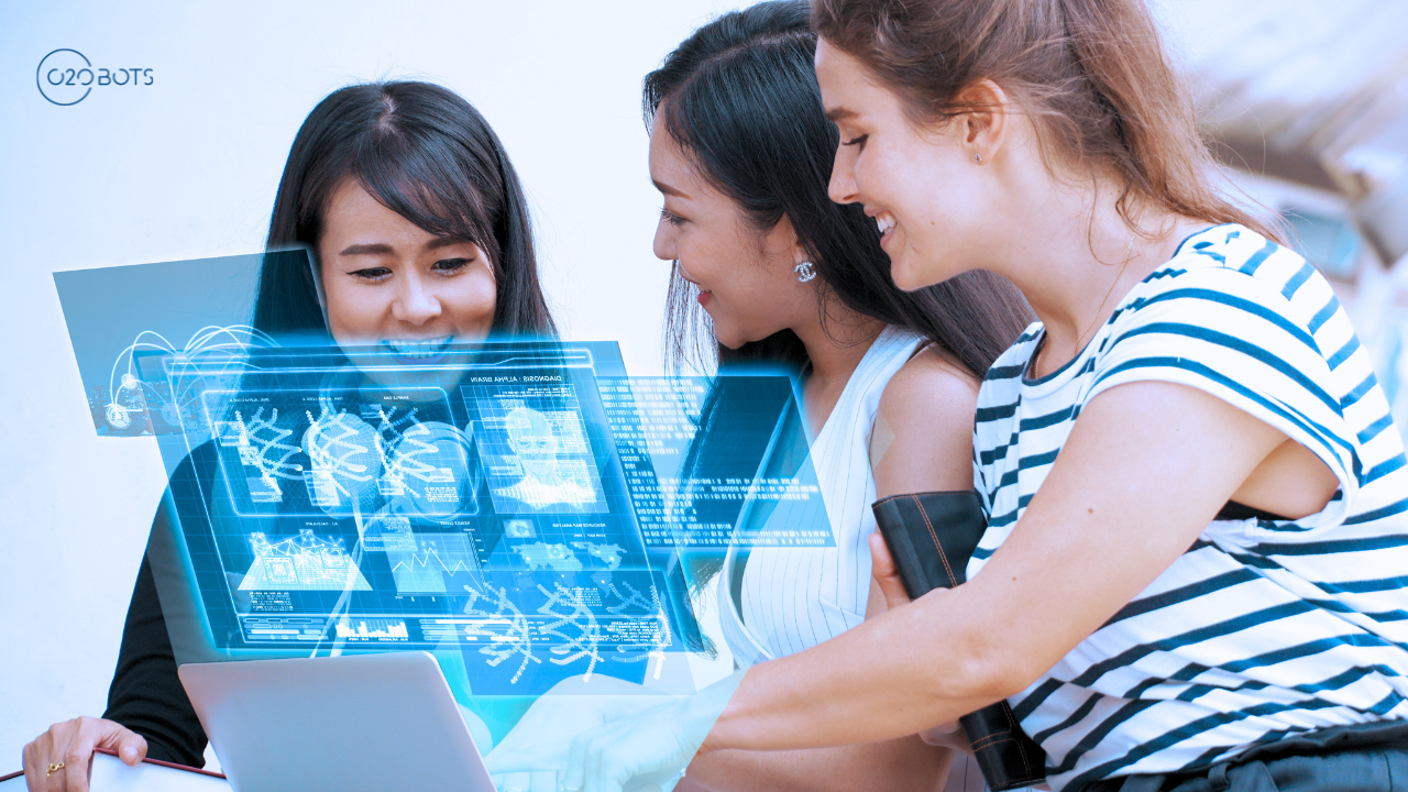 Three women are sitting around a table looking at a laptop computer.