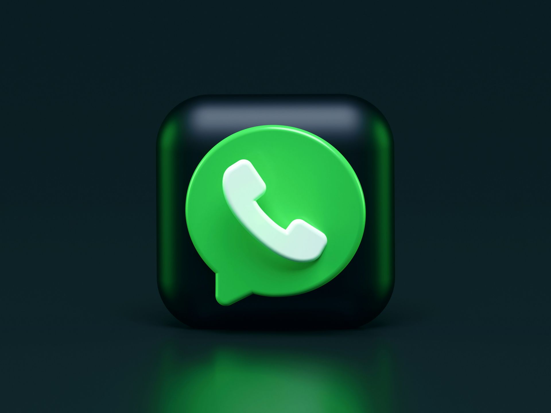 A green whatsapp icon on a black square on a dark background.