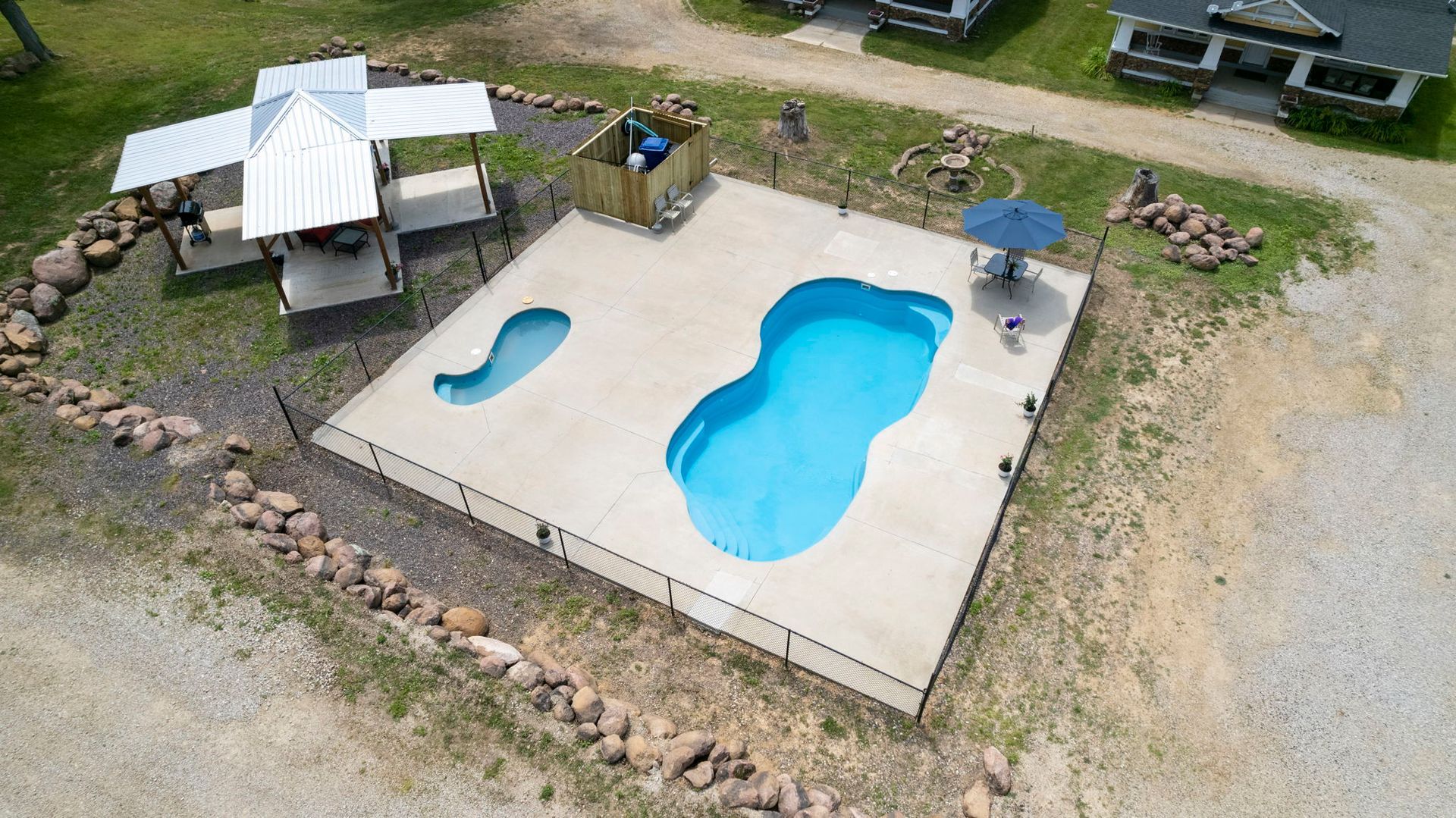 An aerial view of a large swimming pool in a yard.