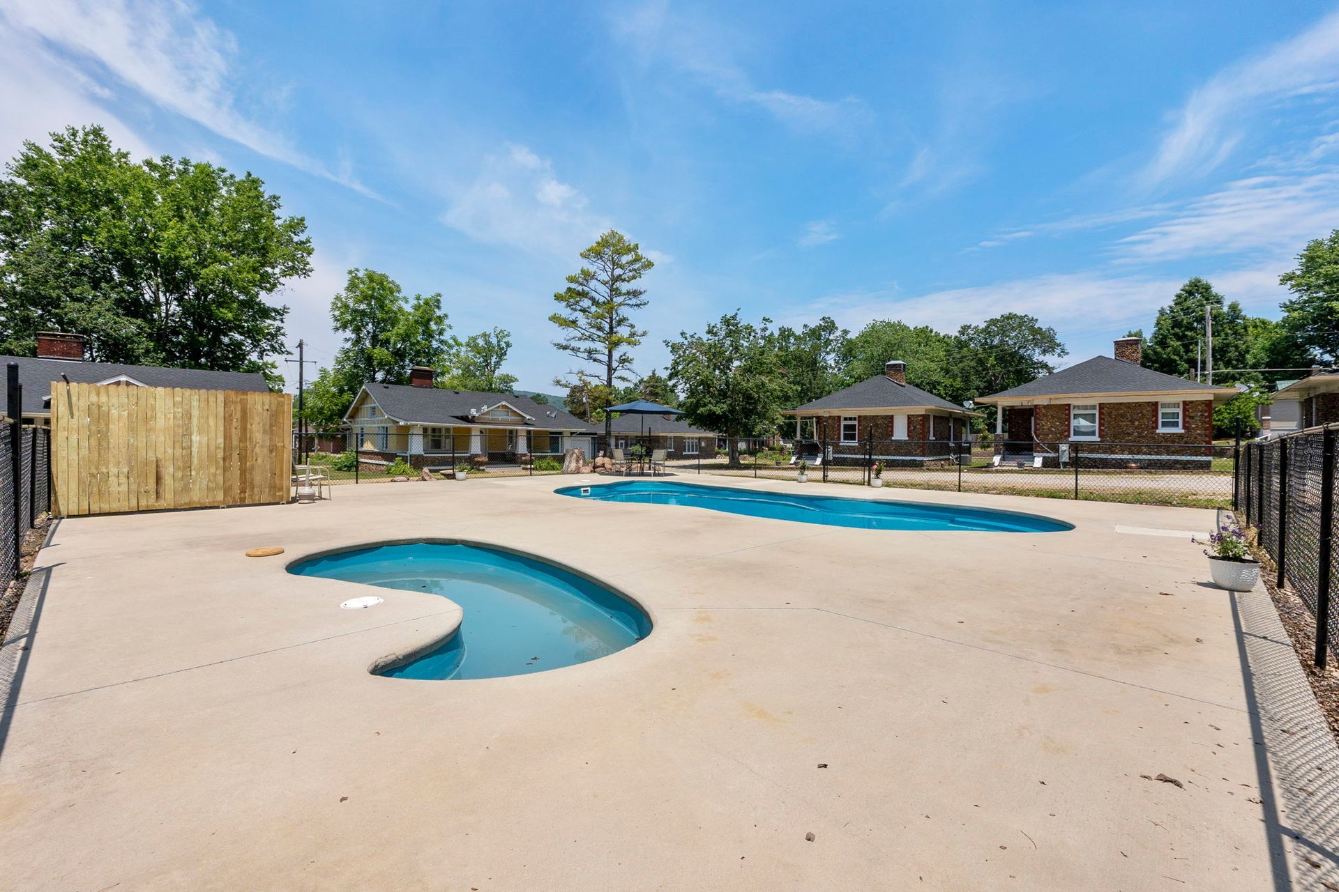 A large swimming pool surrounded by houses on a sunny day