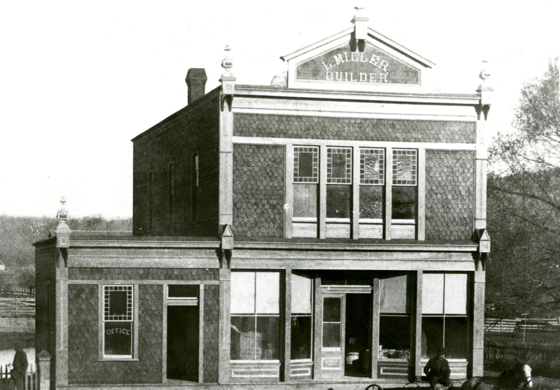 A black and white photo of a building with a sign that says miller 's