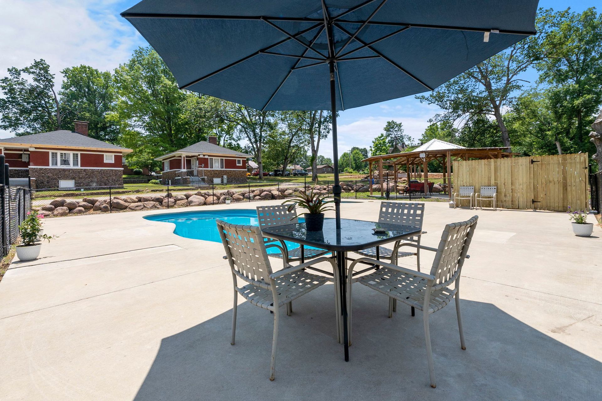 A table and chairs under an umbrella next to a pool