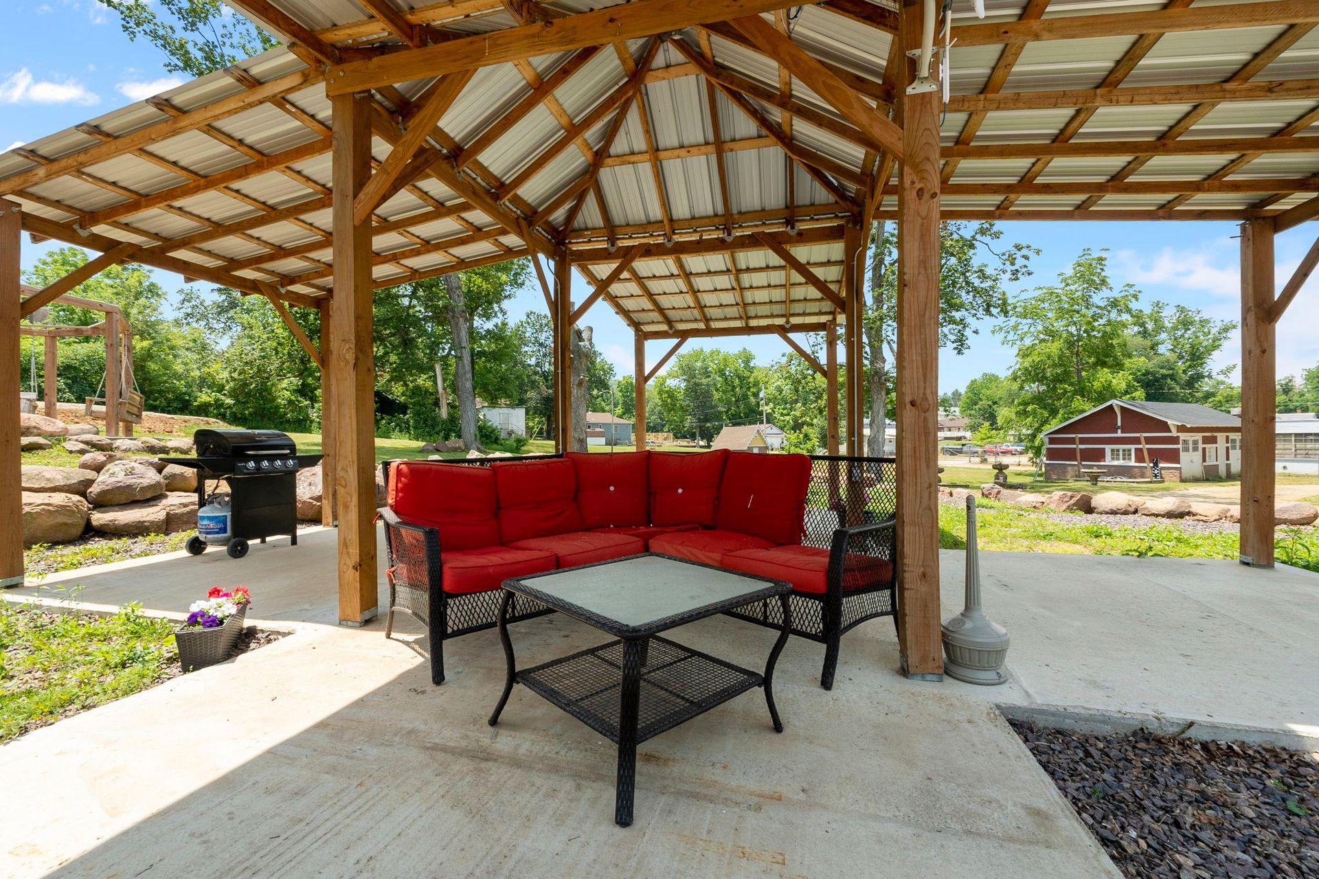 A gazebo with a couch and a table underneath it.