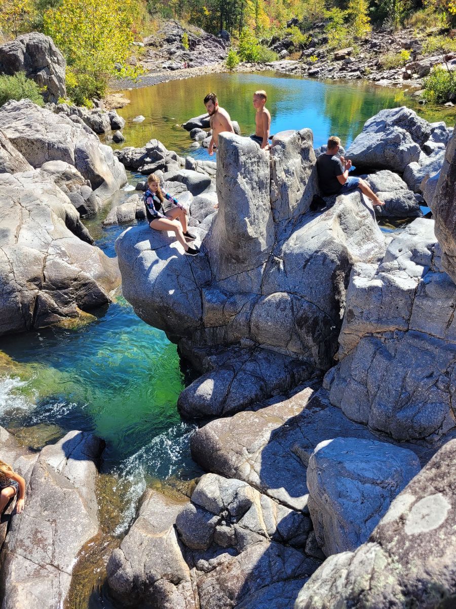 a group of people are standing on top of a row of atvs .