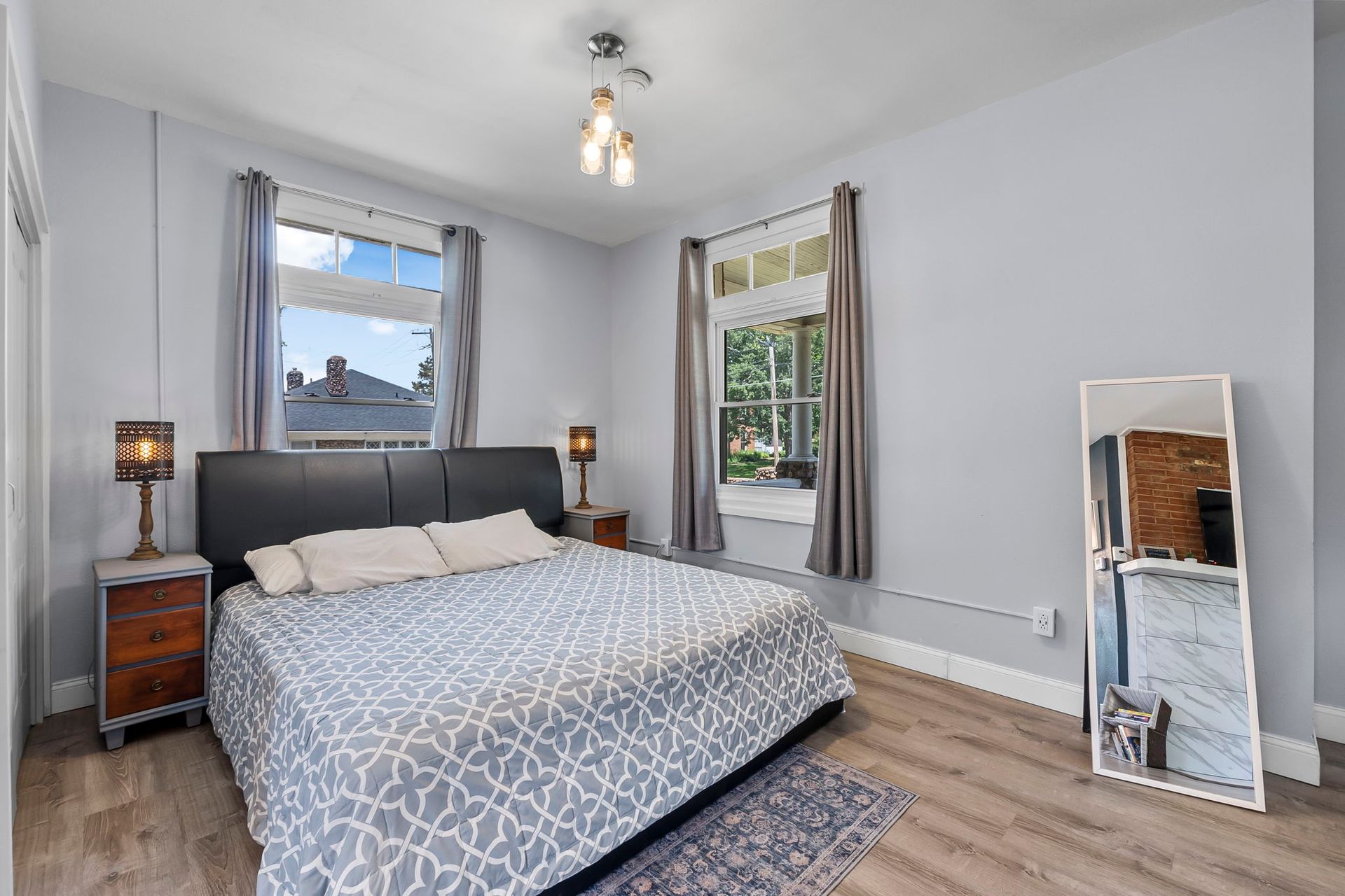 A bedroom with a large bed and a mirror.