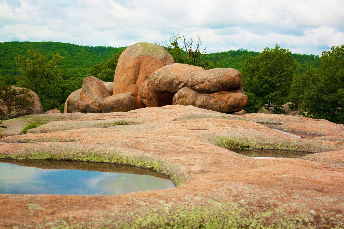 a large rock formation with a pond in the middle of it .