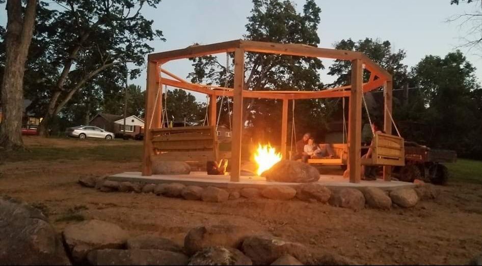 A gazebo with a fire pit in the middle of it