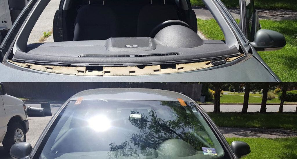 Car with a broken windshield is parked on the side of the road.