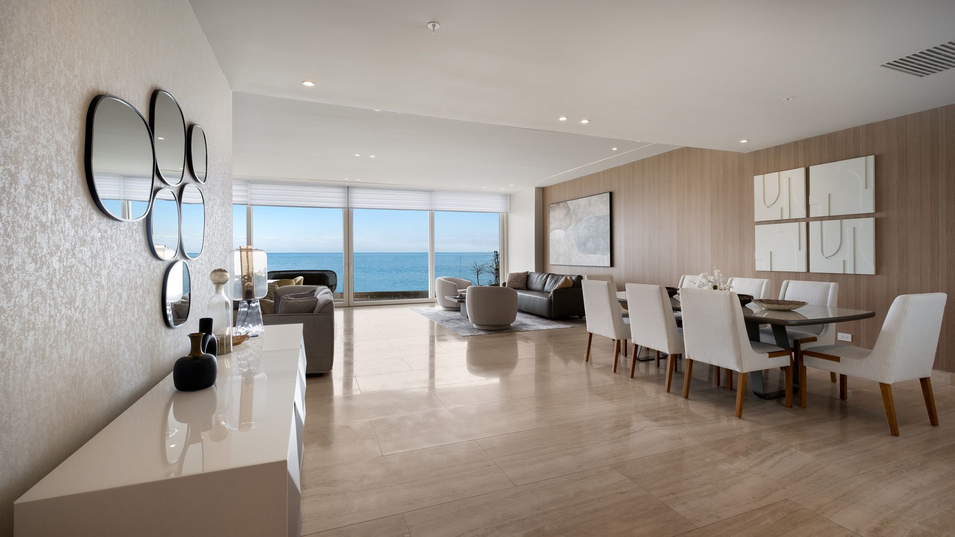 Una sala de estar con mesa de comedor y sillas y vista al mar.