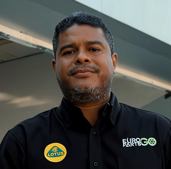 Un hombre que lleva una camisa negra con el logo de un loto.