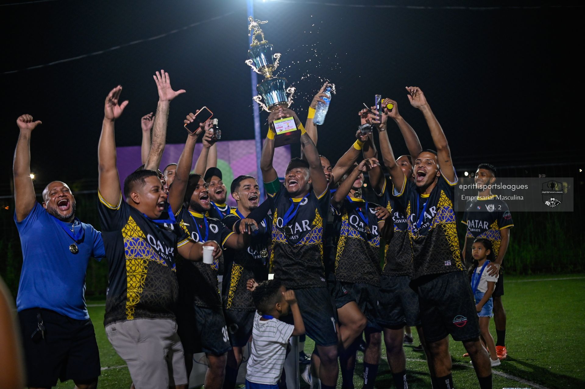 Un grupo de jugadores de fútbol sostiene un trofeo en un campo.