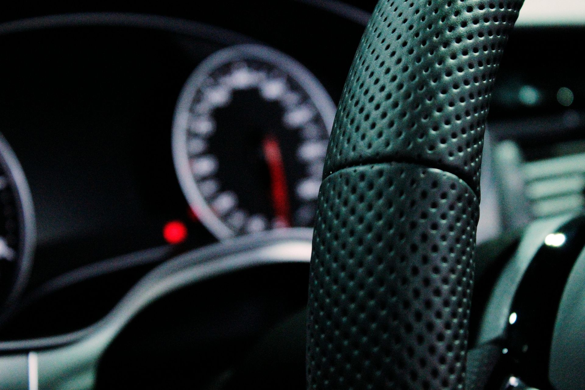 A close up of a car steering wheel and dashboard