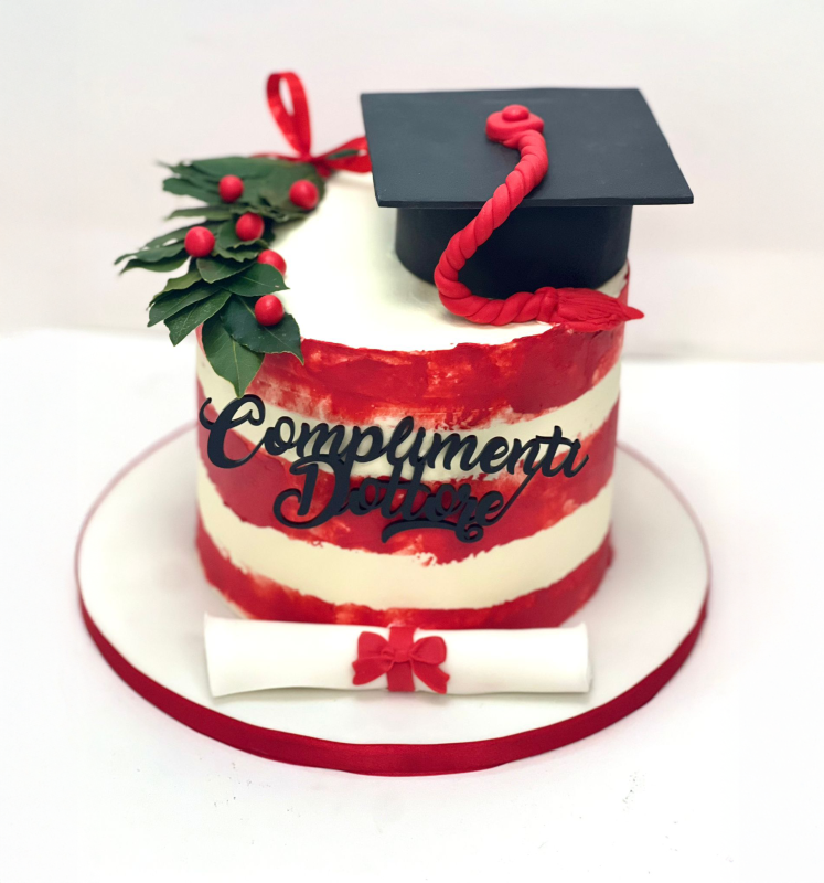 Torta di laurea con glassa rossa e bianca, berretto, pergamena e messaggio
