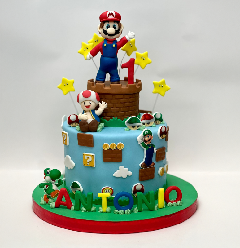 Torta di compleanno a tema Mario con Mario, Toad e Yoshi. Glassa blu con elementi del gioco e scritta