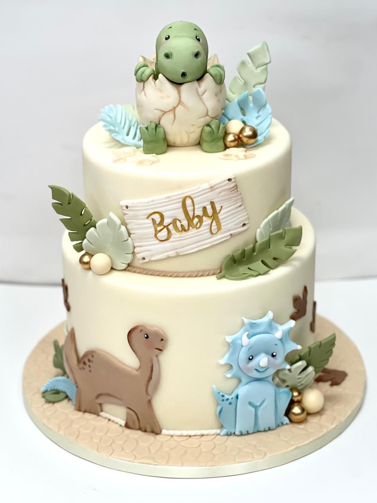 Torta verde decorata con quattro rane, margherite e il numero uno. Al centro c'è una piccola torta.