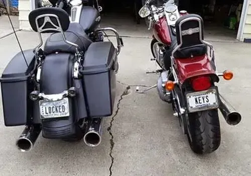 Two parked motorcycles face outward from a garage.