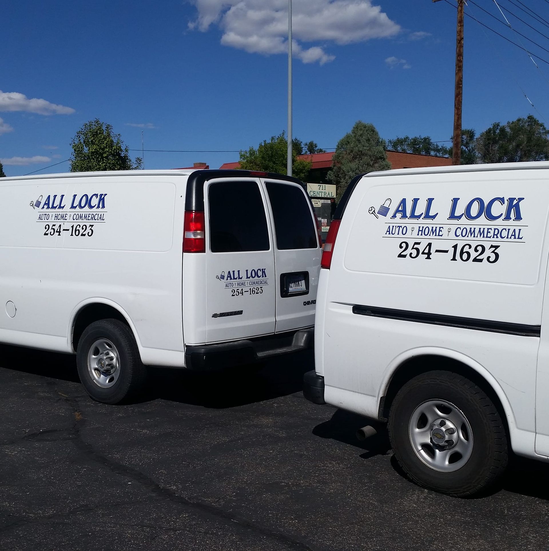 Two white vans with "ALL LOCK" signage